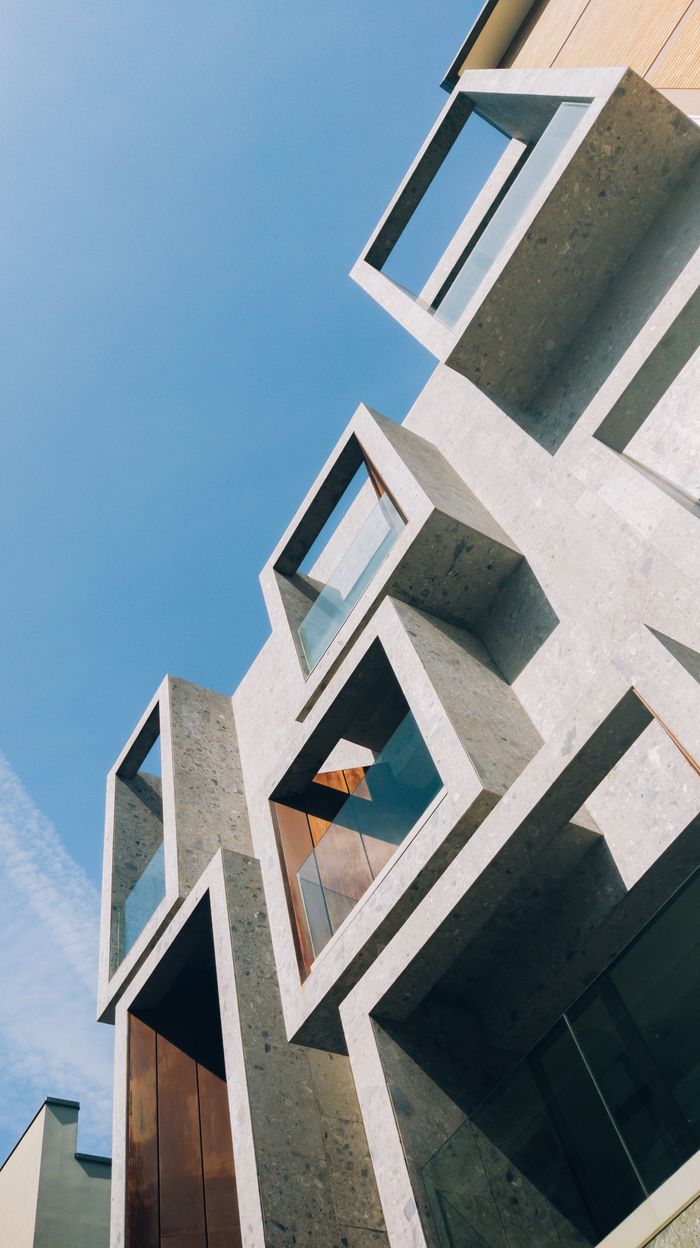 Modern building with geometric design set against a clear blue sky, showcasing contemporary architecture.